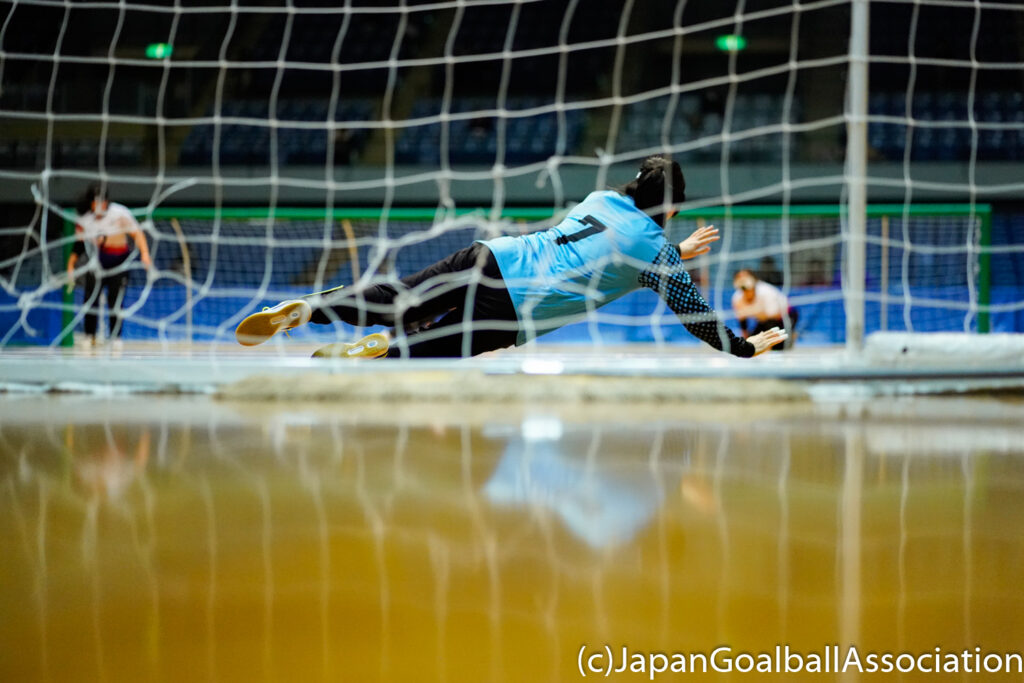 Chunhua Wang of China's women's goalball team spread herself across the front of goal