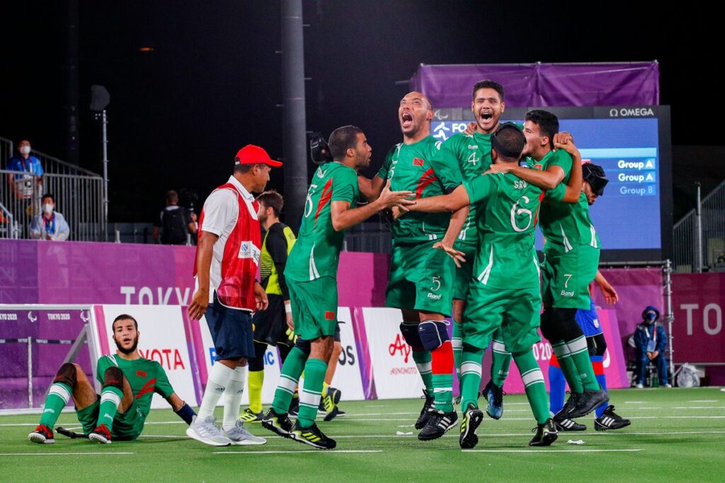 Players and coaches from the Moroccan blind football team jump up and down after claiming a semi-final place at the Tokyo 2020 Paralympic Games