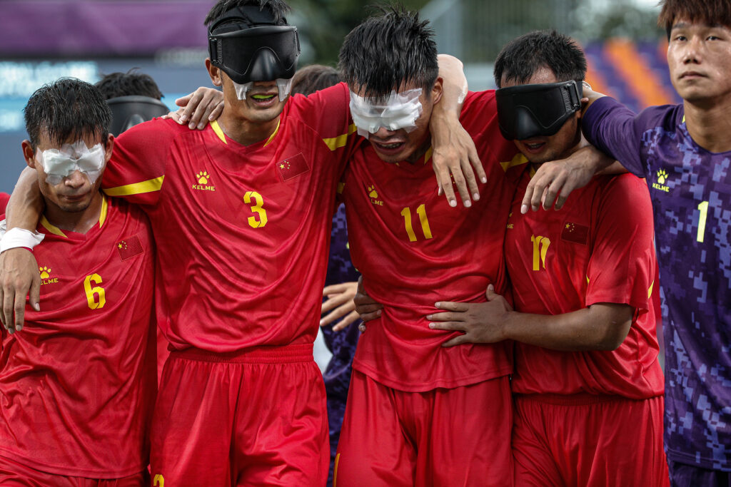 Chinese blind football players link arms and embrace