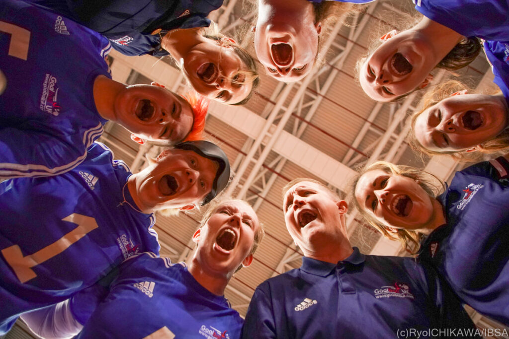 The British women's goalball team are pictured from below as they gather for a team huddle